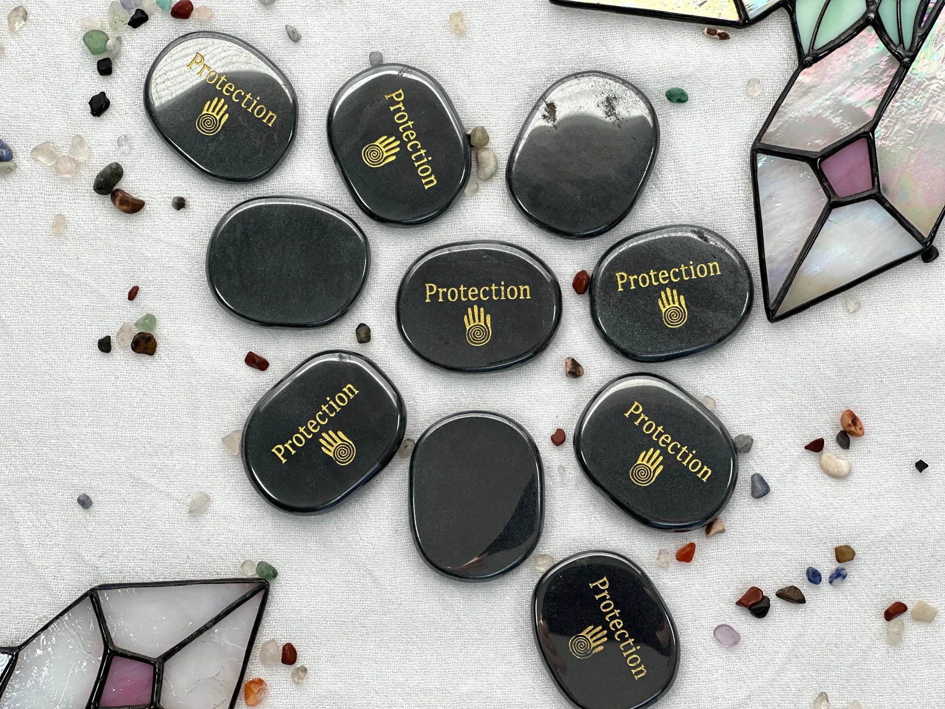 Flat hematite palm stone, with shaman hand printed along with the word protection in gold ink. Engraved in one side. Flat and smooth in both sides